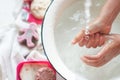 ChildÃ¢â¬â¢s hands under white bowl with water upon water stream Royalty Free Stock Photo